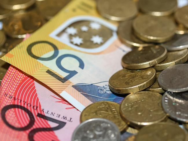 Close up of Australian money, twenty and fifty dollar notes and gold and silver coins scattered on pile.