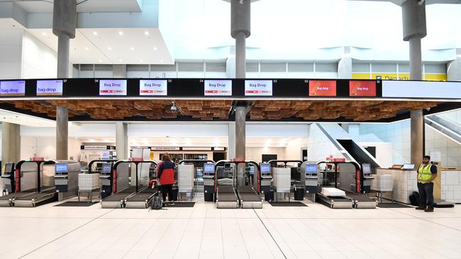 A lone passenger at the Jetstar terminal at Brisbane Airport as Qantas announces further cuts to capacity. Picture: AAP Image/Dan Peled.