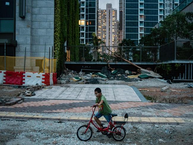 A boy rides his bike on a ruined cycling path destroyed by Typhoon Mangkhut in Tseung Kwan O district in Hong Kong. Picture: AFP