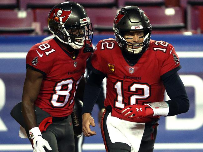 Quarterback Tom Brady #12 of the Tampa Bay Buccaneers congratulates wide receiver Antonio Brown #81 after a touchdown during the 1st quarter of the game against the Washington Football Team at FedExField on January 09, 2021 in Landover, Maryland. (Photo by Patrick Smith/Getty Images)