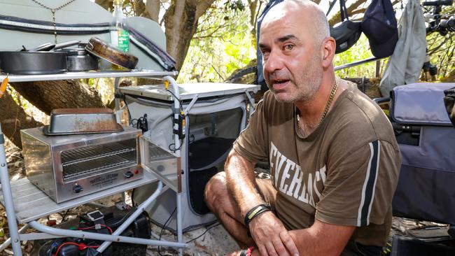 A homeless man with his cooking oven at his camp in a park near Melbourne last year. Picture: Ian Currie