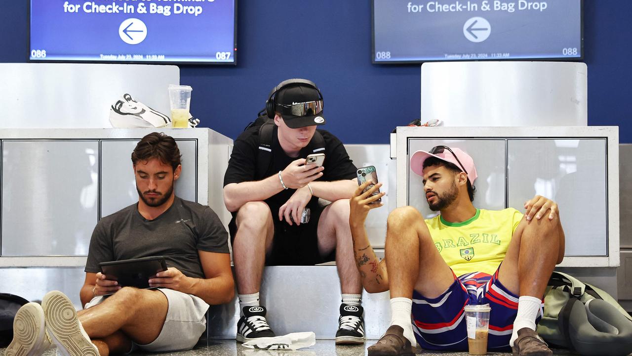 Travellers from France wait on their delayed flight on the floor of the Delta Air Lines terminal at Los Angeles International Airport. Picture: Mario Tama/Getty Images via AFP