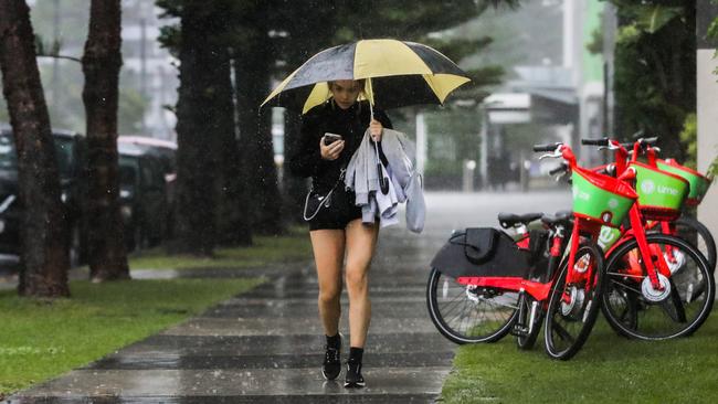 A woman walking in heavy rain in Broadbeach earlier this year. Picture: Nigel Hallett