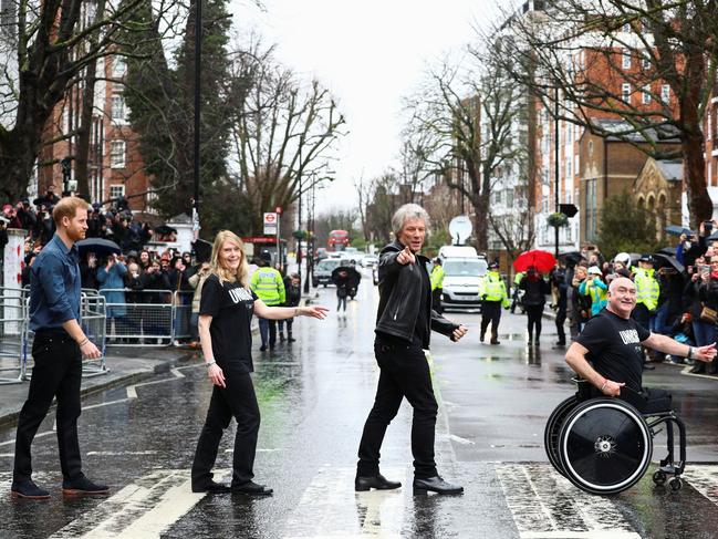 Prince Harry on the famous Zebra crossing The Beetles walked across with and two members of the Invictus Games choir and Bon Jovi. Picture: Getty