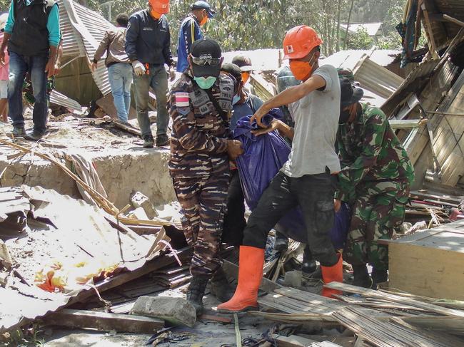 TOPSHOT - Members of a rescue team carry away body bags containing deceased people at Klatanlo village, in East Flores Regency, East Nusa Tenggara, on November 4, 2024, after Mount Lewotobi Laki-Laki erupted overnight. At least six people died after a volcano in eastern Indonesia erupted several times overnight, officials said on November 4, raising the alert level to the highest of a four-tiered system. (Photo by ARNOLD WELIANTO / AFP)