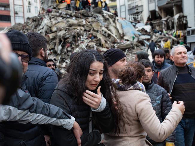 A woman reacts as rescuers search for survivors through the rubble of collapsed buildings in Adana, Turkey. Picture: AFP