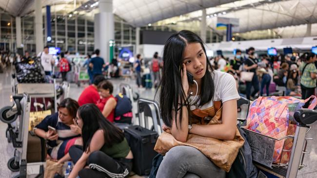 HONG KONG, CHINA - AUGUST 13: Stranded passengers sit near check-in counters as all flights have been cancelled after protesters occupied the Hong Kong International Airport during a demonstration on August 13, 2019 in Hong Kong, China. Pro-democracy protesters have continued rallies on the streets of Hong Kong against a controversial extradition bill since 9 June as the city plunged into crisis after waves of demonstrations and several violent clashes. Hong Kong's Chief Executive Carrie Lam apologized for introducing the bill and declared it "dead", however protesters have continued to draw large crowds with demands for Lam's resignation and the complete withdrawal of the bill. (Photo by Anthony Kwan/Getty Images)