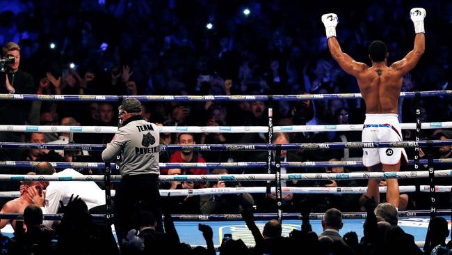 Anthony Joshua celebrates as the referee tends to Russia's Alexander Povetkin. (Photo by ADRIAN DENNIS / AFP)