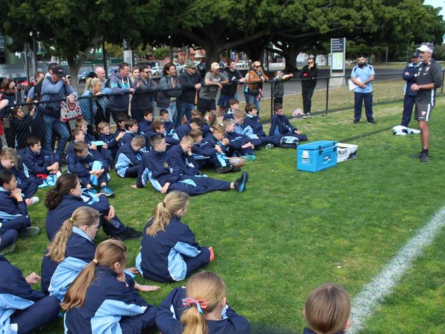 Sydney Swans players visit with NSW primary schools Australian football squads.