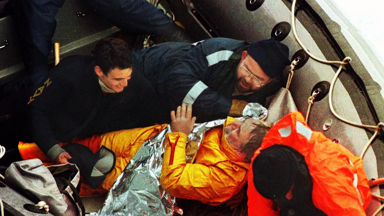British solo yachtsman Tony Bullimore wrapped in a thermal blanket with Navy divers after being rescued from the Southern Ocean.