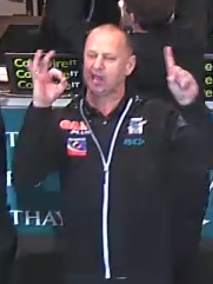 Screenshots of Port Adelaide coach Ken Hinkley celebrating Port Adelaide's win over Adelaide in Showdown 44. Hinkley is seen gesturing the numbers 1-0