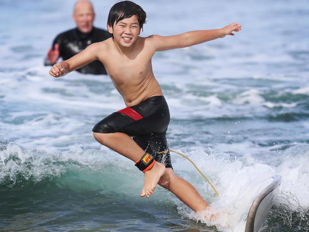 Christopher McClymont, 10 of Sandford learning to surf with his father Michael McClymont at Goat's Beach on Easter Sunday. Picture: LUKE BOWDEN