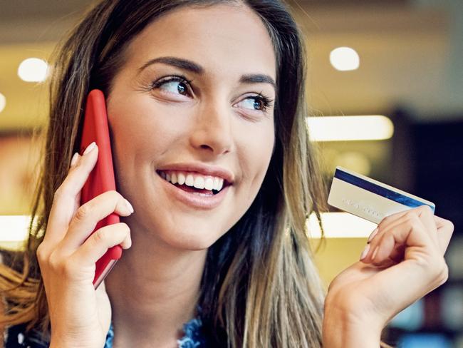 Young girl is sitting in a cafe, and shopping online using her credit card