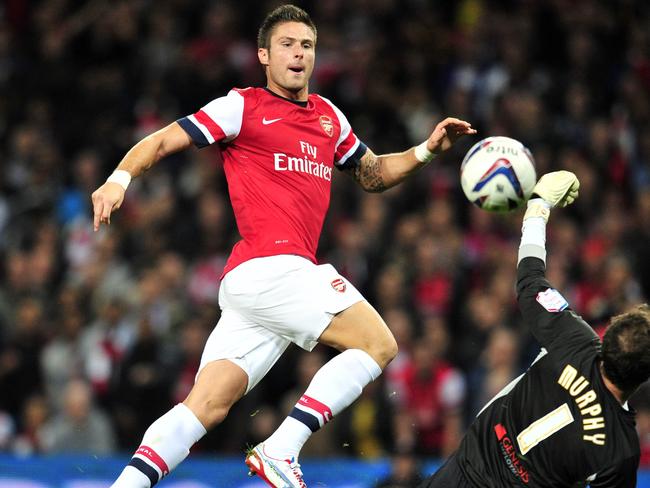 Arsenal's French striker Olivier Giroud scores the opening goal past Coventry City's Irish goalkeeper Joe Murphy during their League Cup third round football match at the Emirates Stadium, London, England, on September 26, 2012. AFP PHOTO/GLYN KIRK RESTRICTED TO EDITORIAL USE. No use with unauthorized audio, video, data, fixture lists, club/league logos or “live” services. Online in-match use limited to 45 images, no video emulation. No use in betting, games or single club/league/player publications.