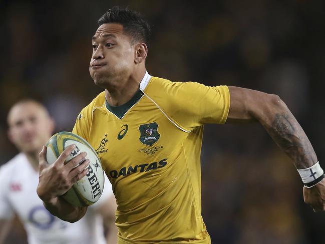 In this June 25, 2016, photo, Australian rugby union player Israel Folau, wearing tape on his wrist adorned with a cross, runs toward the try line to score against England during their rugby union test match in Sydney. Folau, one of the sport's top players, published a message on his Instagram account that said "drunks, homosexuals, adulterers, liars, fornicators, thieves, atheists, idolators. Hell awaits you." (AP Photo/Rick Rycroft)