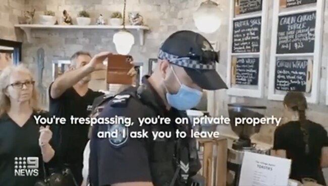 Police arrest coffee shop owner in front of angry customers following multiple alleged COVID-19 health order breaches. Image: Nine Network.