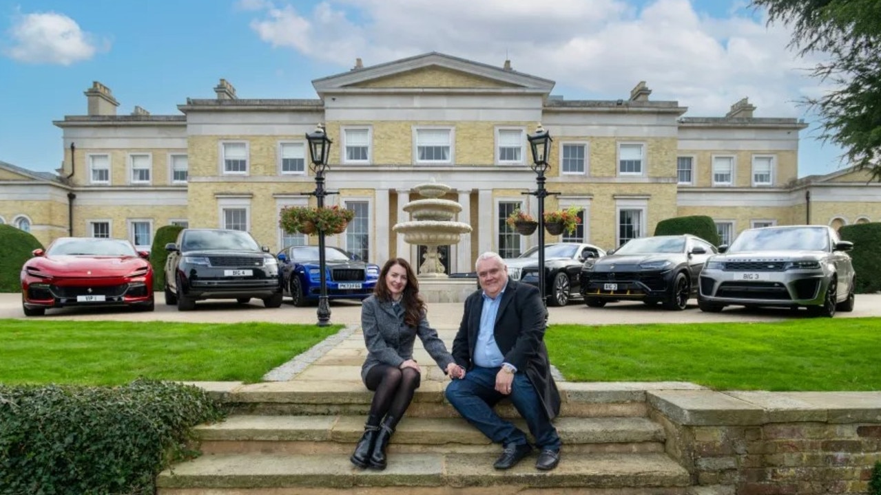 Peter Waddell, 58, with his wife Gabby and some of their cars pictured outside their home. Picture: John McLellan / The Sun