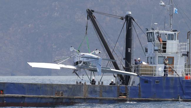 The plane is removed from water in January 2015 as members of Tasmania Police photograph it. Picture: LUKE BOWDEN