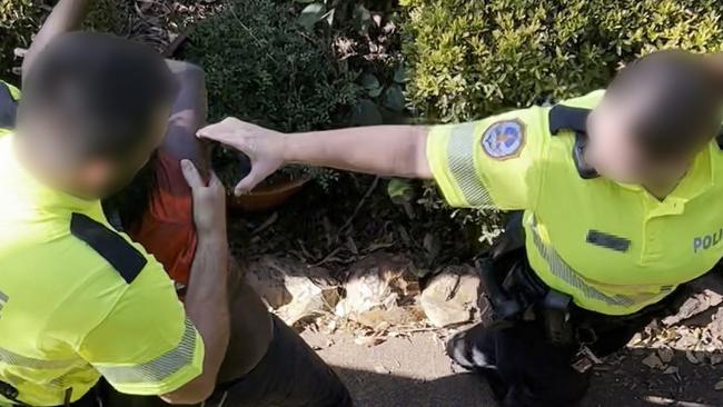 Eleven-year-old Benny struggles with Northern Territory police before being dragged into a paddy wagon on Friday.