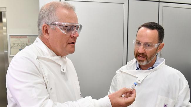 Prime Minister Scott Morrison studies a vial of the University of Queensland’s first and now halted Covid-19 vaccine candidate with Professor Trent Munro. Picture: AAP.