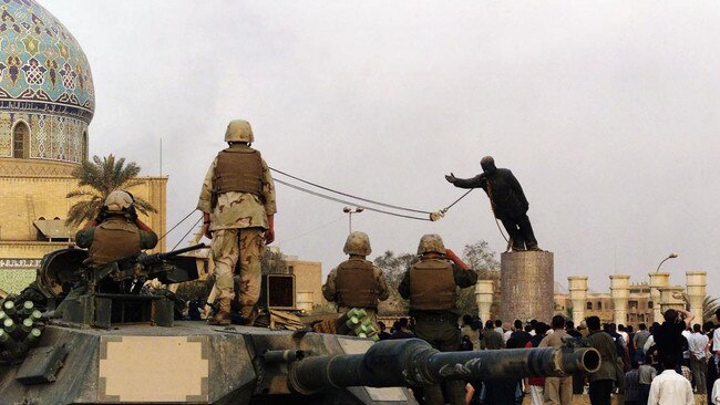 Americans watch on as Iraqis topple a statue of their ex-dictator on April 9, 2003. Picture: Getty Images/The Times