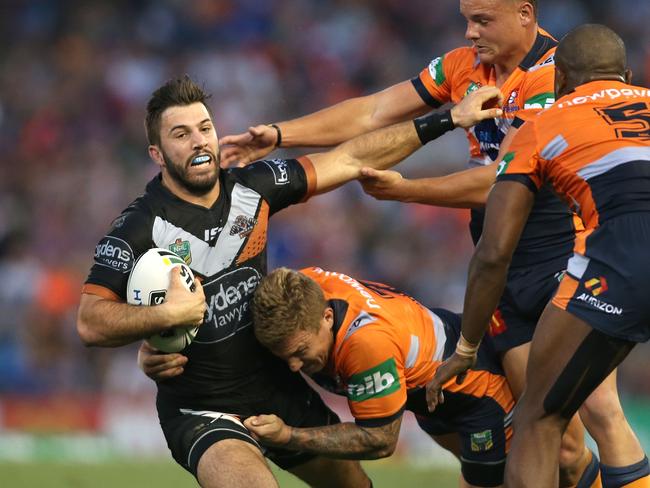 NEWCASTLE, AUSTRALIA - APRIL 10: James Tedesco of the Tigers is tackled by Trent Hodkinson of the Knights during the round six NRL match between the Newcastle Knights and the Wests Tigers at Hunter Stadium on April 10, 2016 in Newcastle, Australia. (Photo by Tony Feder/Getty Images)