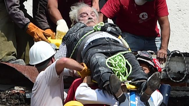 A man is pulled out of the rubble alive following a quake in Mexico City on September 19, 2017. A powerful earthquake shook Mexico City on Tuesday, causing panic among the megalopolis' 20 million inhabitants on the 32nd anniversary of a devastating 1985 quake. The US Geological Survey put the quake's magnitude at 7.1 while Mexico's Seismological Institute said it measured 6.8 on its scale. The institute said the quake's epicenter was seven kilometers west of Chiautla de Tapia, in the neighboring state of Puebla.  / AFP PHOTO / Ronaldo SCHEMIDT