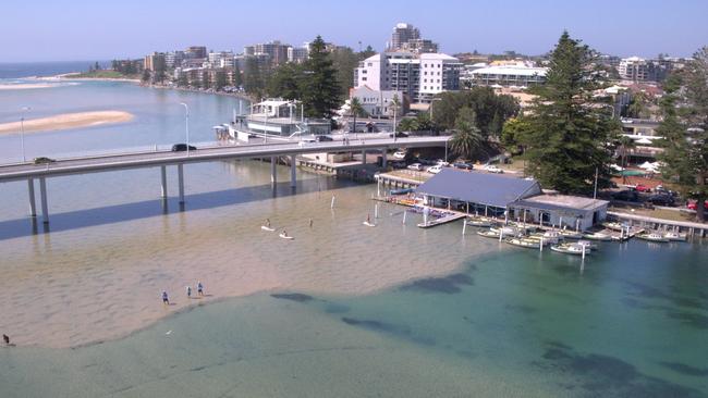 Drone image of The Entrance, showing the encroaching sandbar. The owners of The Entrance Boat Shed are calling for urgent dredging.