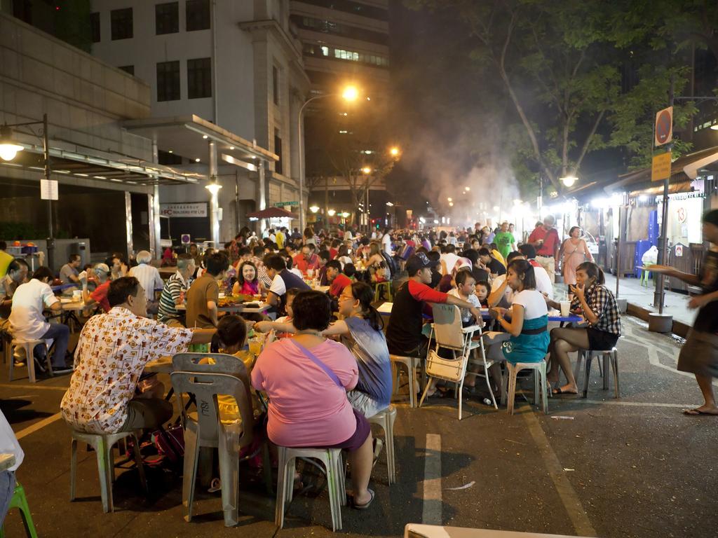 People eating satay on the street in Singapore.