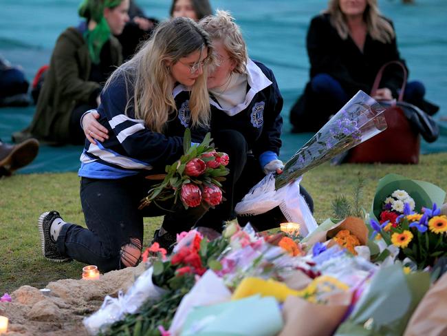 Two Princes Hill Secondary College students lay flowers at the Reclaim Princes Park vigil for Eurydice Dixon. Picture: Mark Stewart