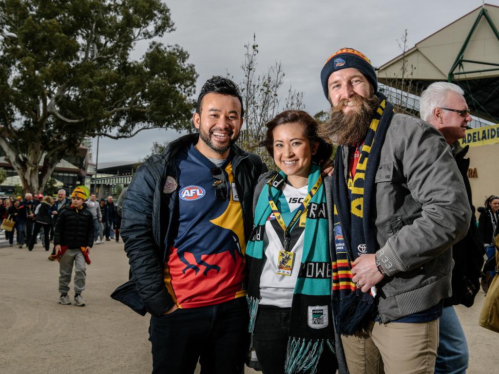 AFL supporters Tim Siv, Tina Richardson and Matt Richardson pause for a photo outside the oval before heading into Showdown 45. AAP Image/ Morgan Sette