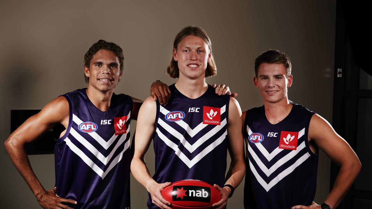 Liam Henry, Hayden Young and Caleb Serong of the Fremantle Dockers pose for a photograph during the first round of the 2019 AFL Draft.