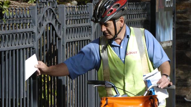 SENDING A LETTER BY AUSTRALIA POST. POSTAL DELIVERY OFFICER POSTMAN JOHN GREGORY RIDING HIS BICYCLE DOING HIS ROUND IN NORTH ADELAIDE.