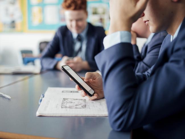 Male student using phone during a class.