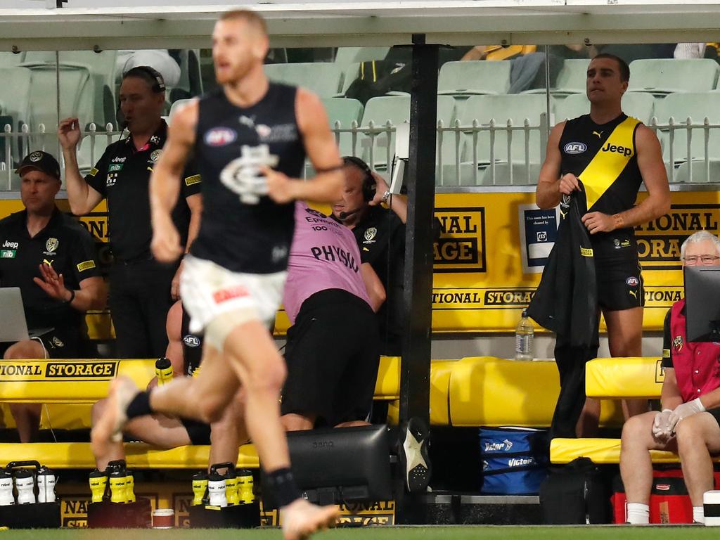 Medical Sub player Jack Ross of the Tigers takes off his warm-up jacket on the bench.