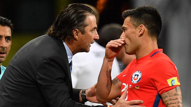 Chile's Spanish coach Juan Antonio Pizzi (L) speaks to Chile's midfielder Charles Aranguiz