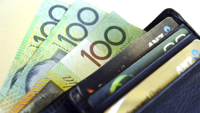 $100 Australian dollar notes pop out of a wallet with credit cards, pictured in Brisbane. (AAP Image/Dan Peled)