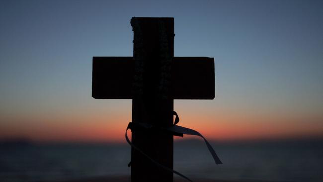 Anzac Sunset at Ari Burnu cemetry on Gallipoli Peninsula , a small cross placed next to Grave stone of Tropper K E Watt on the 10th Aust Lighthorse ,killed July 11 1915 .Pic;gregg Porteous