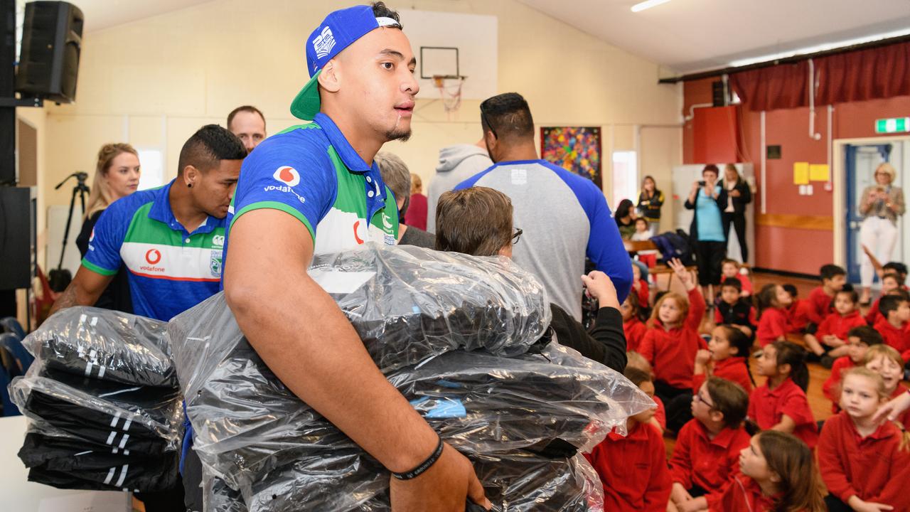 Eliesa Katoa hands out Warriors jackets during a New Zealand Warriors visit to Bishopdale School