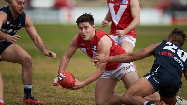 North's Matt McDonough gets a handball off before being tackled by South's Rigby Barnes at Prospect Oval. Picture: Matt Loxton