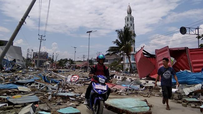 Residents make their way along a street full of debris after an earthquake and tsunami hit Palu. Picture: AFP