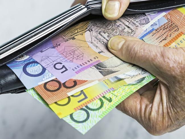 Payment. Close-up, senior female hands taking Australian banknotes (cash, currency) from purse containing many credit cards.  Horizontal, studio, copy space, spread notes.