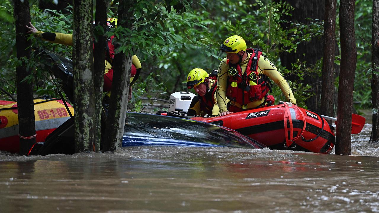 Police and emergency services search after a car was found in floodwaters in Elimbah Tuesday. Picture: Lyndon Mechielsen