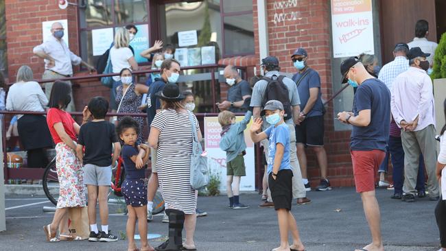 Families lining up at a West Melbourne vaccination clinic. Picture: David Caird