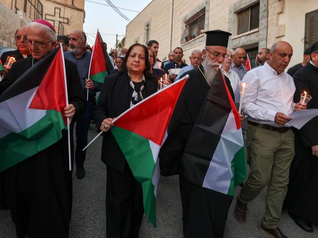 Palestinian Christians wave national flags during a demonstration in solidarity with the people of Gaza in the village of Jifna, north of Ramallah in the occupied West Bank. Picture: AFP