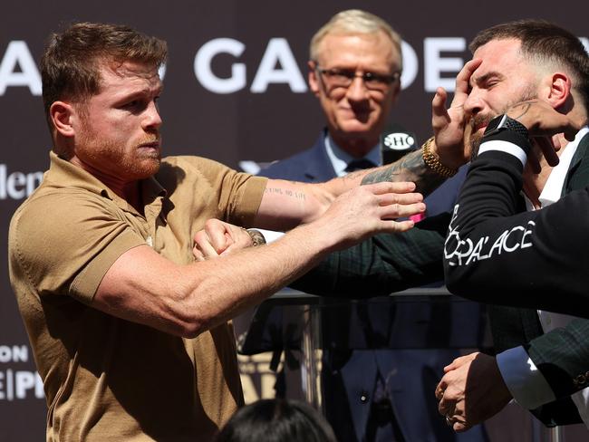 Canelo Alvarez slaps Caleb Plant during a face-off.