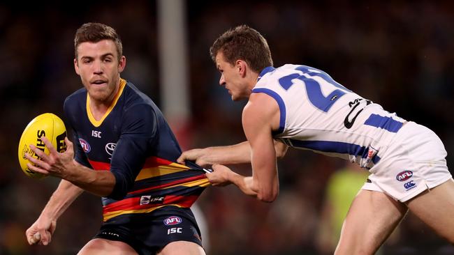 Kayne Turner of the Kangaroos attempts to tackle Crow Paul Seedsman at Adelaide Oval on Sunday. Picture: James Elsby/AFL Media/Getty Images