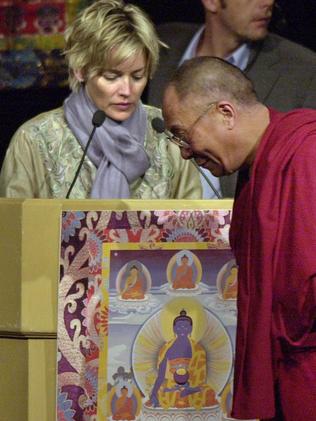 The Dalai Lama and actress Sharon Stone bow to honour heroes of compassion. Picture: AP