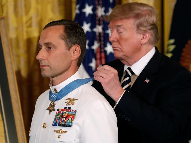 U.S. President Donald Trump awards the Medal of Honor to Retired Navy Master Chief Special Warfare Operator (Sea, Air, and Land) Britt Slabinski for “conspicuous gallantry” in the East Room of the White House in Washington, U.S., May 24, 2018. REUTERS/Kevin Lamarque - RC14EA0EC360