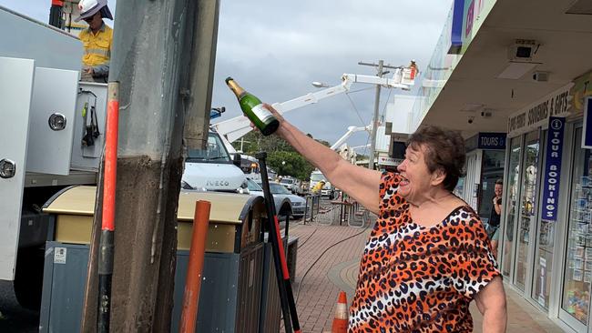 Ruth Modin celebrate the long-awaited removal of the power poles with champagne. Picture: supplied